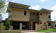 Street view of small lot house on steep site